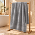 gray Sofia 90x160 cm cotton bath sheet – styled on an oak towel stand in a spa bathroom